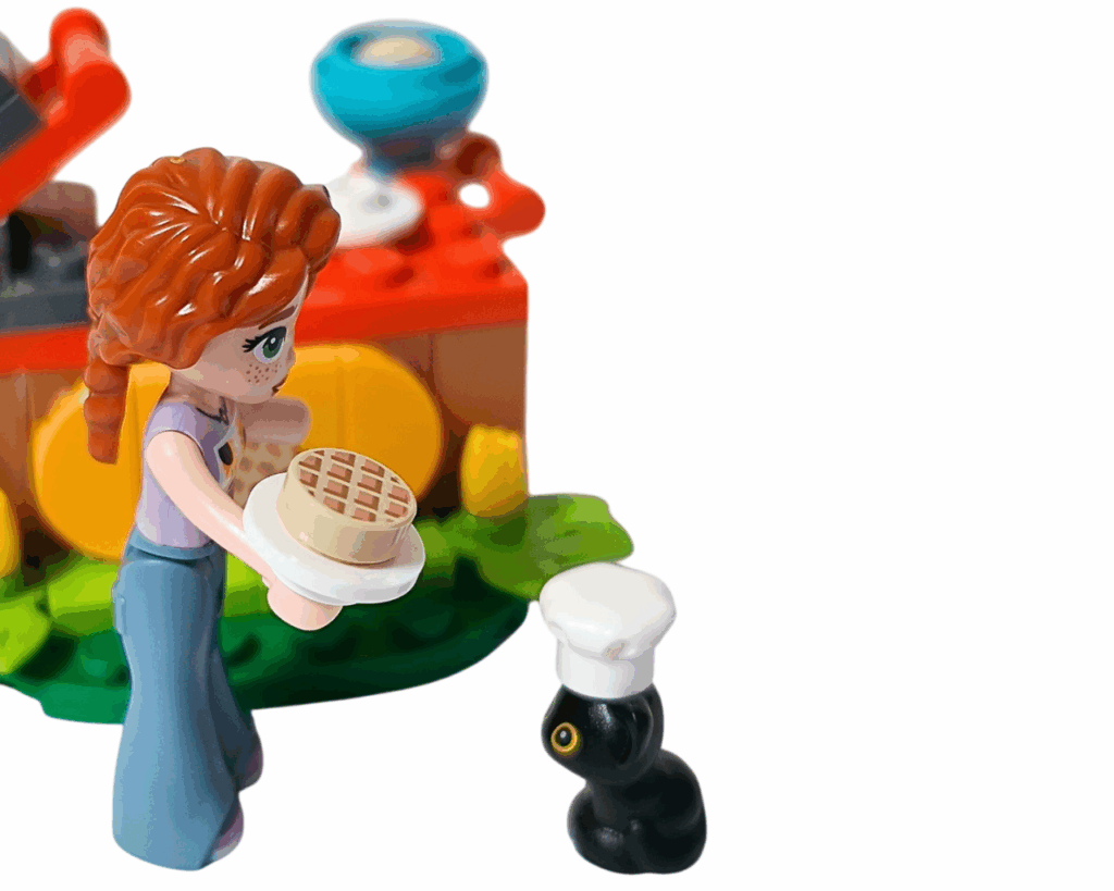 LEGO Friends 30696 オータムのワッフル屋さん 完成シーン。オータムが焼きたてのワッフルを手に持ち、黒ネコのプルートに差し出している