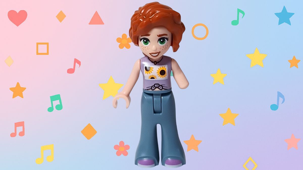 LEGO Friends 30696 オータム ミニドール紹介アイキャッチ画像。 ひまわり柄のラベンダートップスとブルーのパンツを着たオータムが笑顔で立っている。 背景にはハートや星、音符などのカラフルなモチーフが散りばめられ、明るく楽しい雰囲気を演出している。
