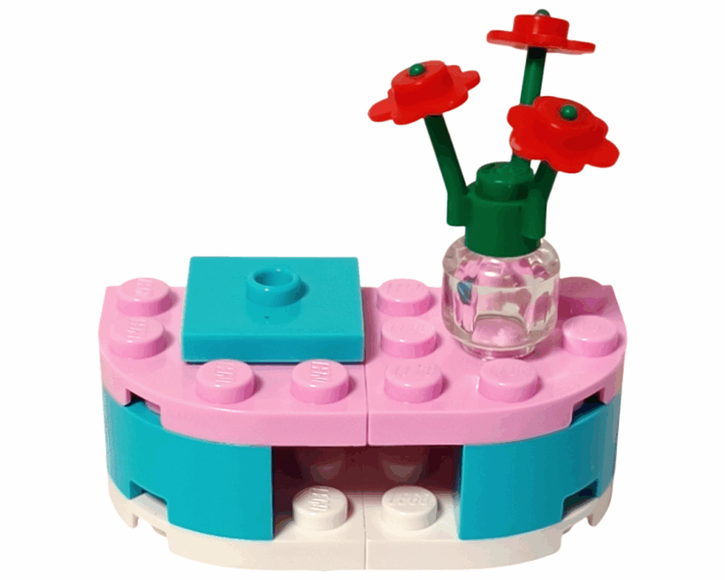 丸いシェルフの上に透明の花瓶と赤い花が飾られている