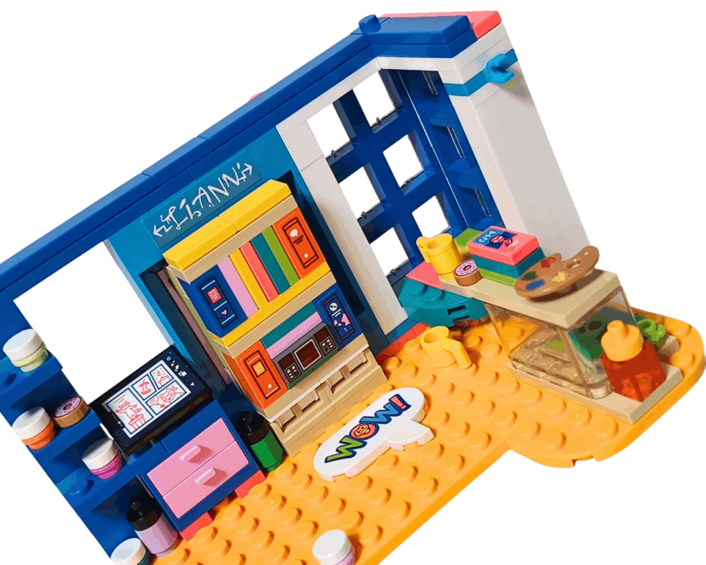 LEGO Friends 41739 リアンの部屋 完成。 左にピンクの引き出し付きアートデスク、中央にカラフルな棚、右側にテラリウムとコーナーテーブル。上にはドーナツ・カップ・絵の具パレットなどが置かれている。