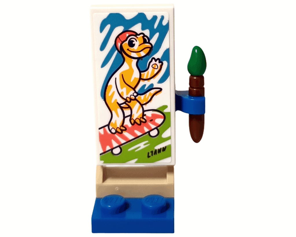 LEGO Friends 41739 リアンの部屋 キャンバス作品。 白いキャンバスにスケートボードに乗るオレンジ色のヤモリが描かれ、右側に緑の筆が立てかけられている。キャンバス下部に「LIANN」のサインがある。