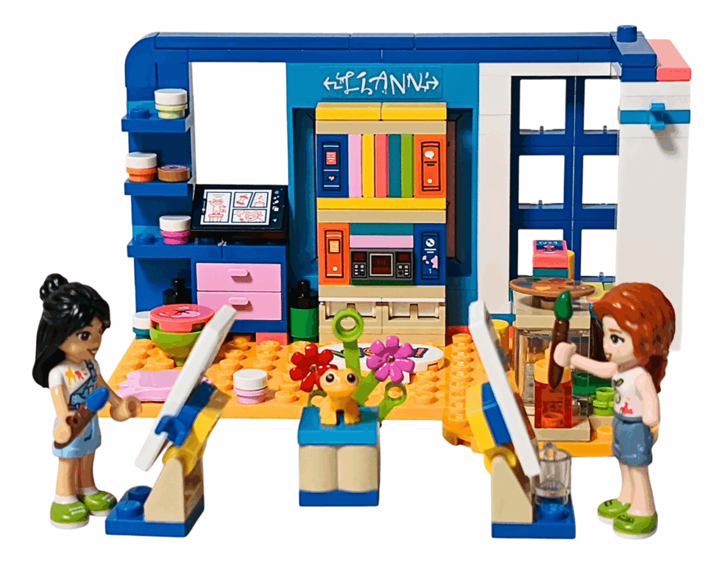 LEGO Friends 41739 リアンの部屋 完成シーン。 リアンとオータムがそれぞれキャンバスを前に筆を持ち、中央の台にポップコーンのフィギュアと花が置かれている。 背後にはカラフルな棚と「LIANN」のサインが見える。