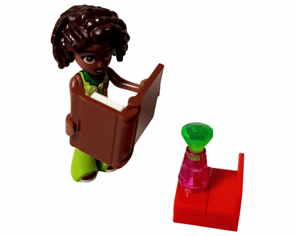 LEGO Friends 42668 アリヤが茶色の本を読んでいるシーン。横に赤い台と緑の宝石の小物が置かれている。