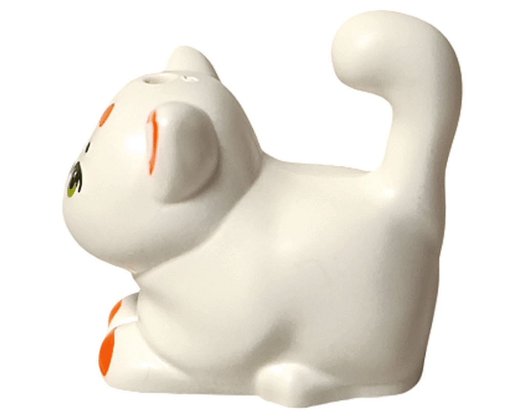 LEGO Friends 42668 チュロス 動物フィギュア 左側。白いネコが首をかしげて座っている姿。オレンジ模様とグリーンの目が特徴的な横向きの姿。