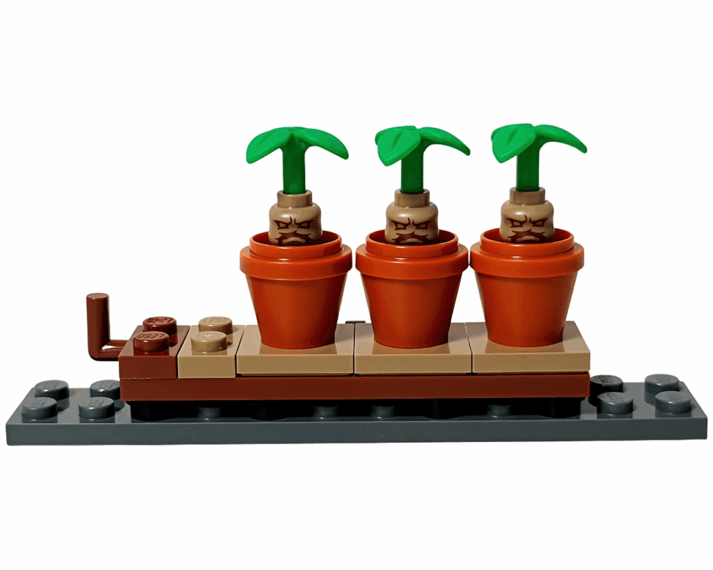 LEGO Harry Potter 76445 ホグワーツ城：薬草学の授業 マンドレイク鉢植え台。 ダークグレーの土台の上に、オレンジ色の鉢が3つ並び、 それぞれ怒った表情のマンドレイクが植えられている。