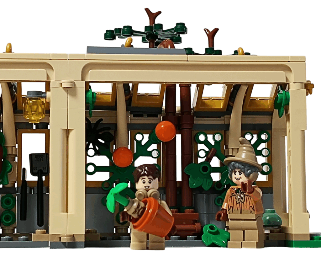 LEGO Harry Potter 76445 ホグワーツ城：薬草学の授業 ネビルのマンドレイク実習。 ネビル・ロングボトムがオレンジの鉢を両手に持ち、背後でスプラウト先生が合図を送る。 壁にはオレンジ色の実をつけた植物が伸び、温室内にランプが灯っている。