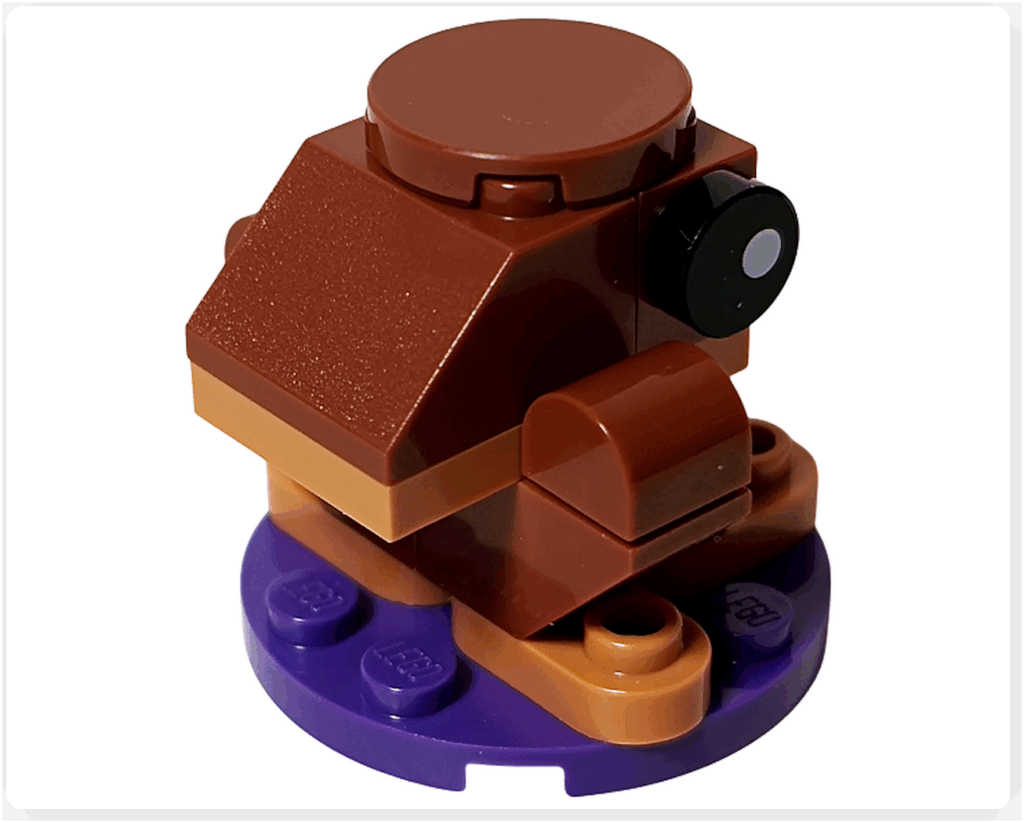 LEGO Harry Potter 76456「ハリー・ポッター アドベントカレンダー2025」11日目の完成品背面。 チョコレート色のボディと黒い目を持つカエル型のミニモデルが、紫色の円形ベース上に配置されている背面アングル。