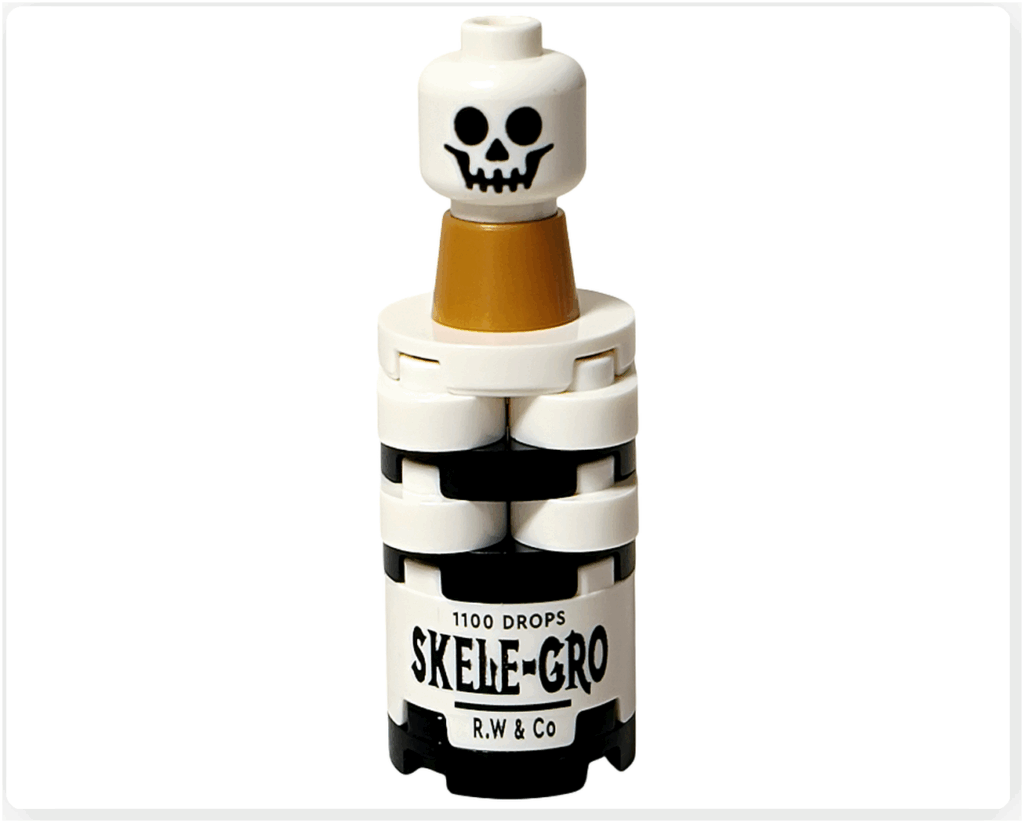 LEGO Harry Potter 76456「ハリー・ポッター アドベントカレンダー2025」18日目の完成モデル。 白と黒のボトル型ビルドに「SKELE-GRO」の文字がプリントされ、上部に金色キャップと骸骨モチーフの飾りが付いている。