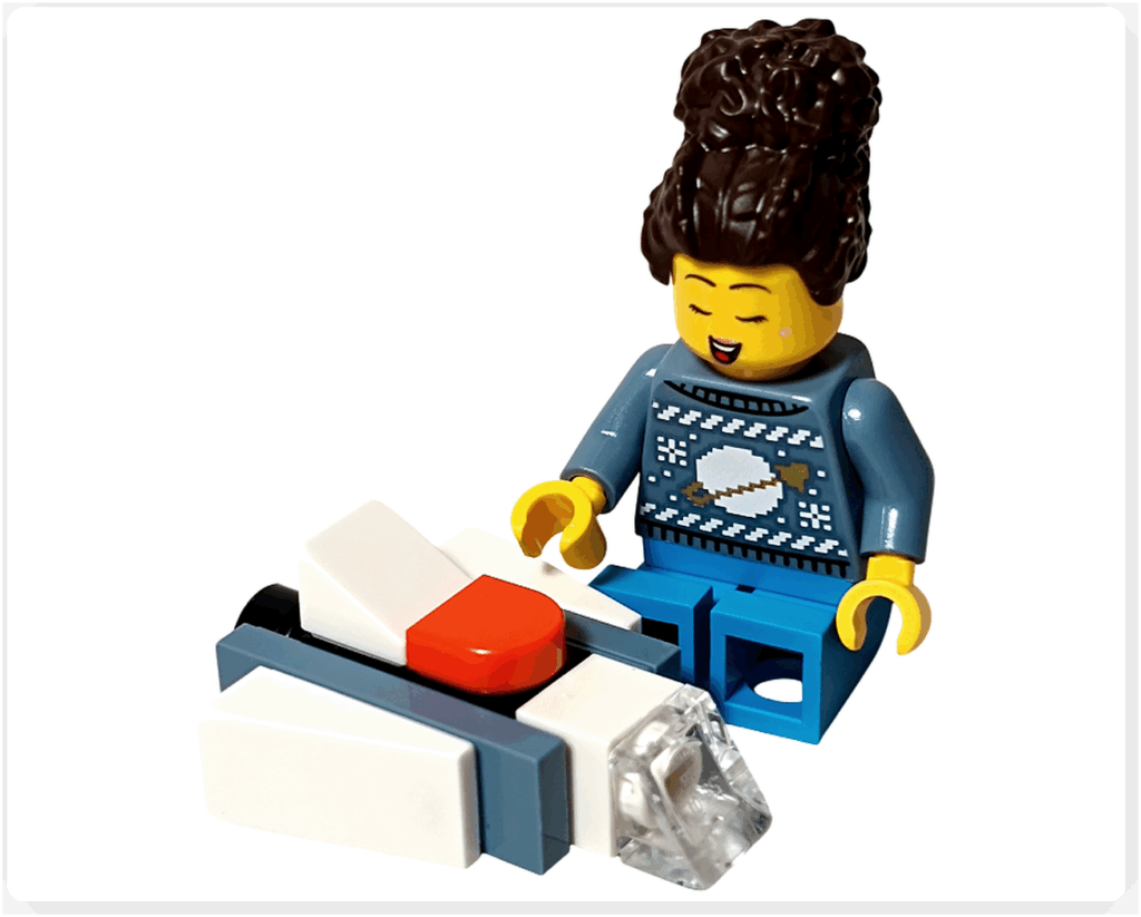 LEGO CITY 60475 Advent Calendar 2025（14日目）女性ミニフィグがおもちゃの宇宙船を手元で整え、ゆったり座っているシーン写真。