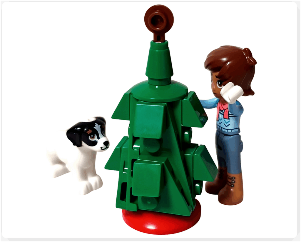 LEGO Friends 41758「アドベントカレンダー2023」12日目のシーン。レオがクリスマスツリーを飾り付け、白い犬デイジーがそばでお手伝いしたそうに見つめている情景です。