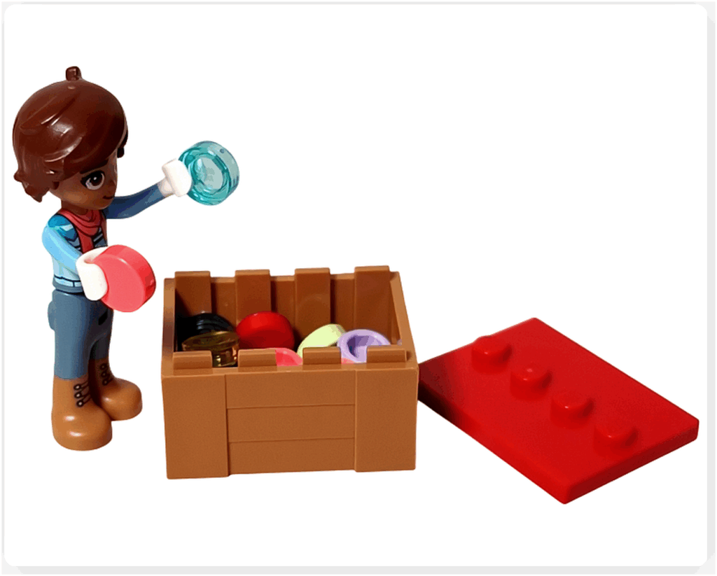 LEGO Friends 41758「アドベントカレンダー2023」13日目のシーン。レオのミニドールがブラウンのボックスから透明タイルや丸タイルを手に取り、クリスマスツリーの飾り付けを準備している様子を写した写真です。