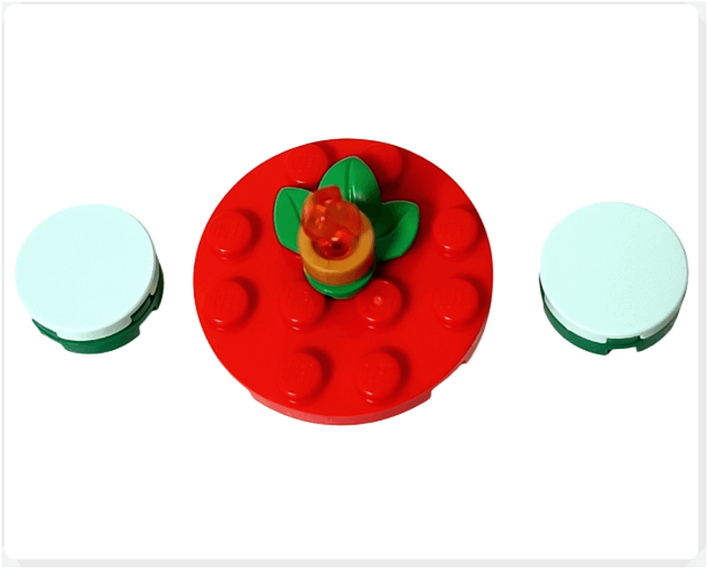 LEGO Friends 41758「アドベントカレンダー2023」16日目のデザートテーブルを上から撮影。赤い円形テーブルがイチゴやリンゴのように見えるフルーツ風デザインで、中央にキャンドルが飾られています。