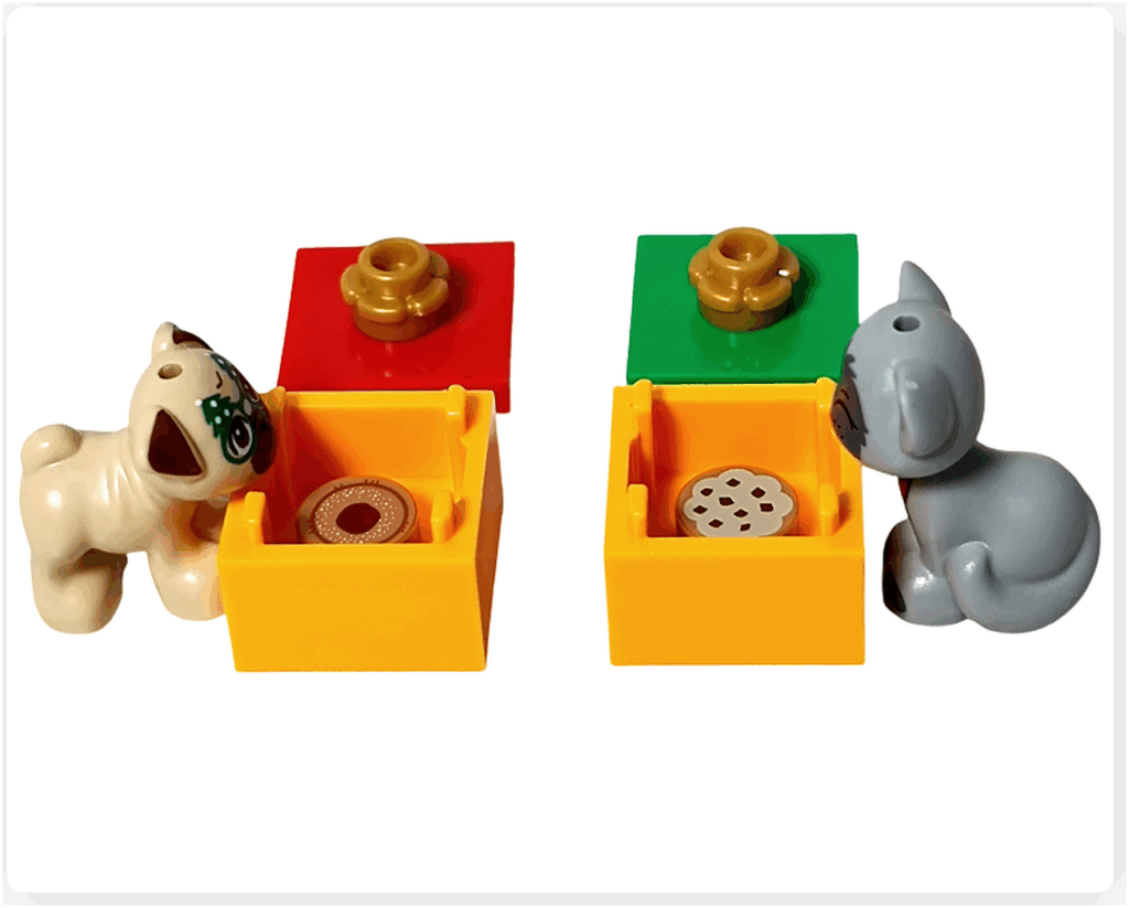 LEGO Friends アドベントカレンダー2023 19日目のシーン。黄色いギフトボックスのふたが開き、内側におやつパーツが入っている。犬のダンゴとガートルードがうれしそうにのぞき込んでいる様子。