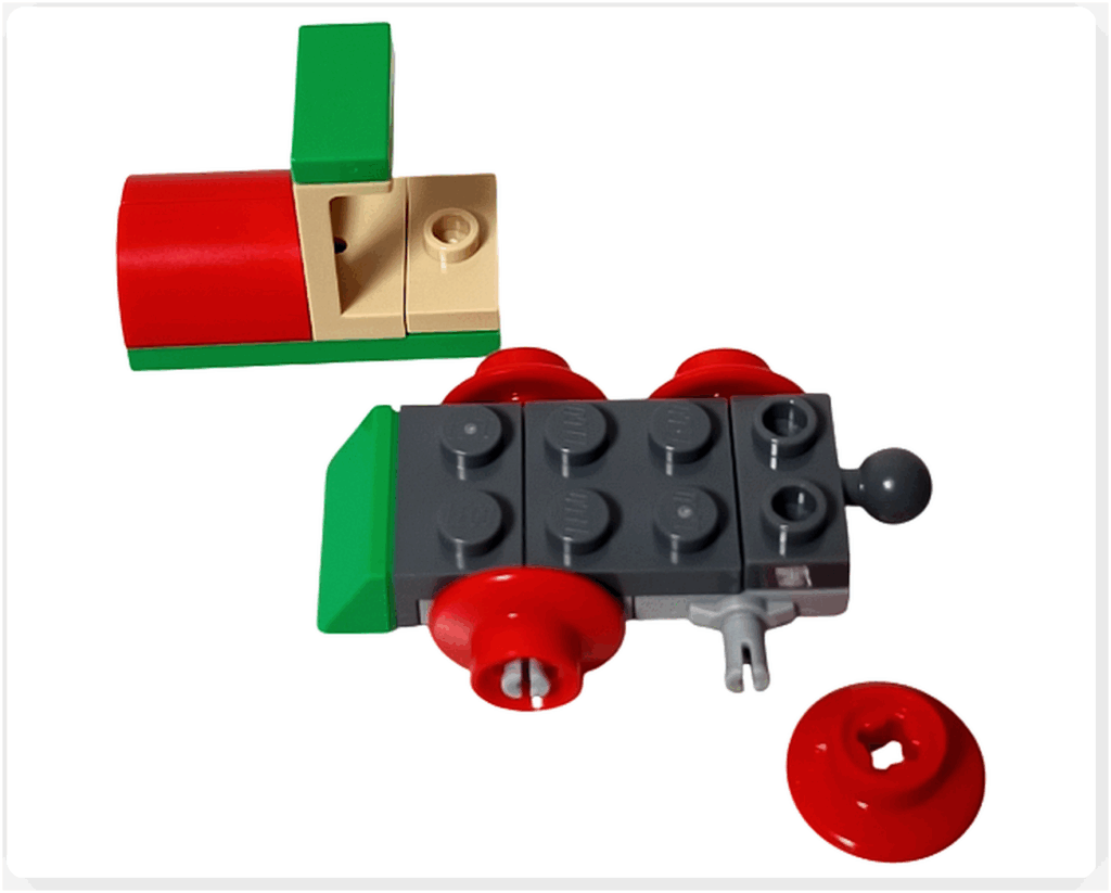 LEGO Friends アドベントカレンダー2023 21日目の組立途中。緑と赤のボディ部分と、赤い丸い車輪パーツがついたシャーシが半分ほど組み上がっている状態。