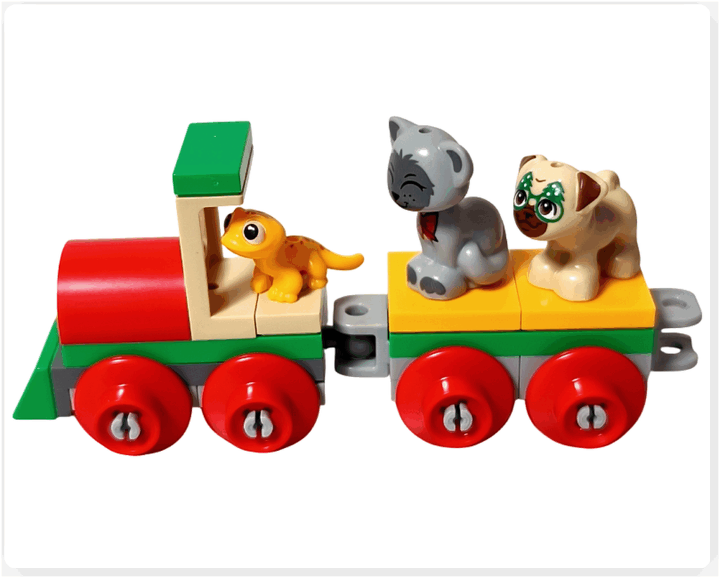LEGO Friends アドベントカレンダー2023 22日目のシーン。赤と緑の機関車と黄色い貨車が連結され、貨車の上にガートルードとダンゴが乗り、ポップコーンが運転席に座っている様子。