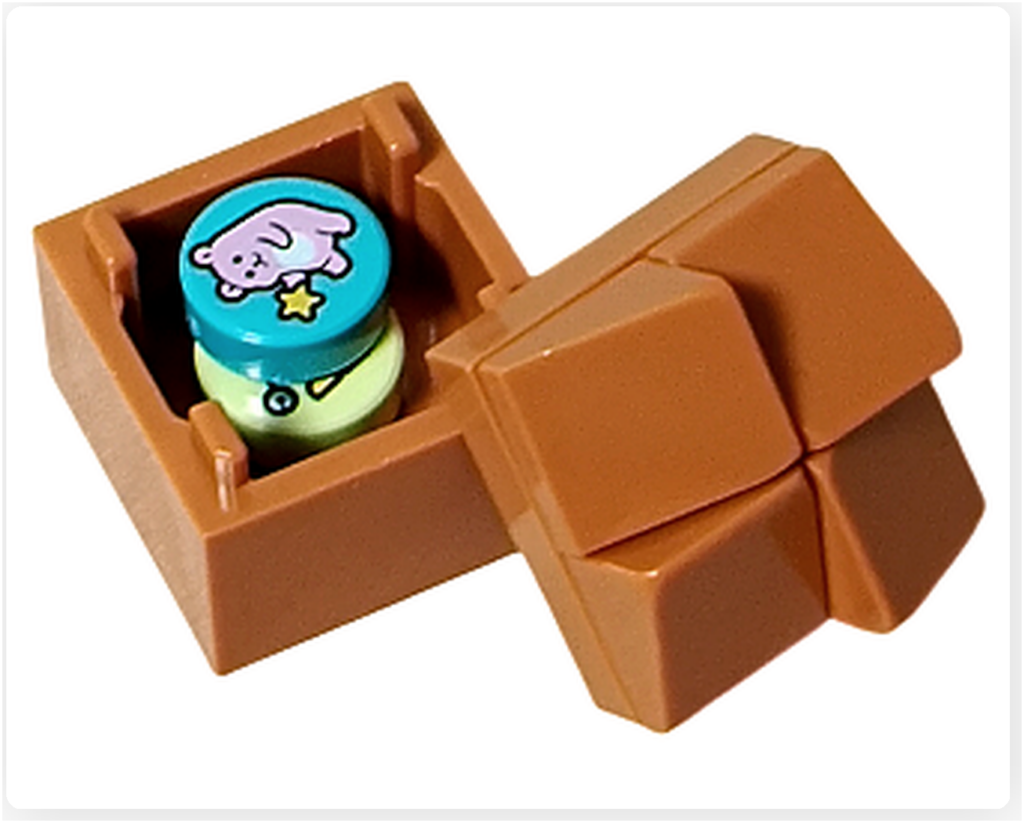 レゴ フレンズ 42674 コミックショップとゲームセンター。メダルストックの小箱。茶色のボックスの中に、イラスト入りのゲーム用メダルパーツが収納されている。