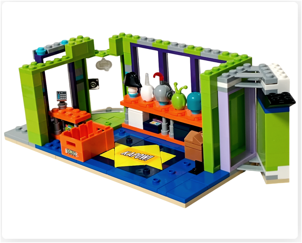 レゴ フレンズ 42674 組立レビュー第2部の写真。1階コミックショップ店内にコミックストックボックスを配置した状態。レジ横の床にオレンジ色のストックボックスが置かれている。