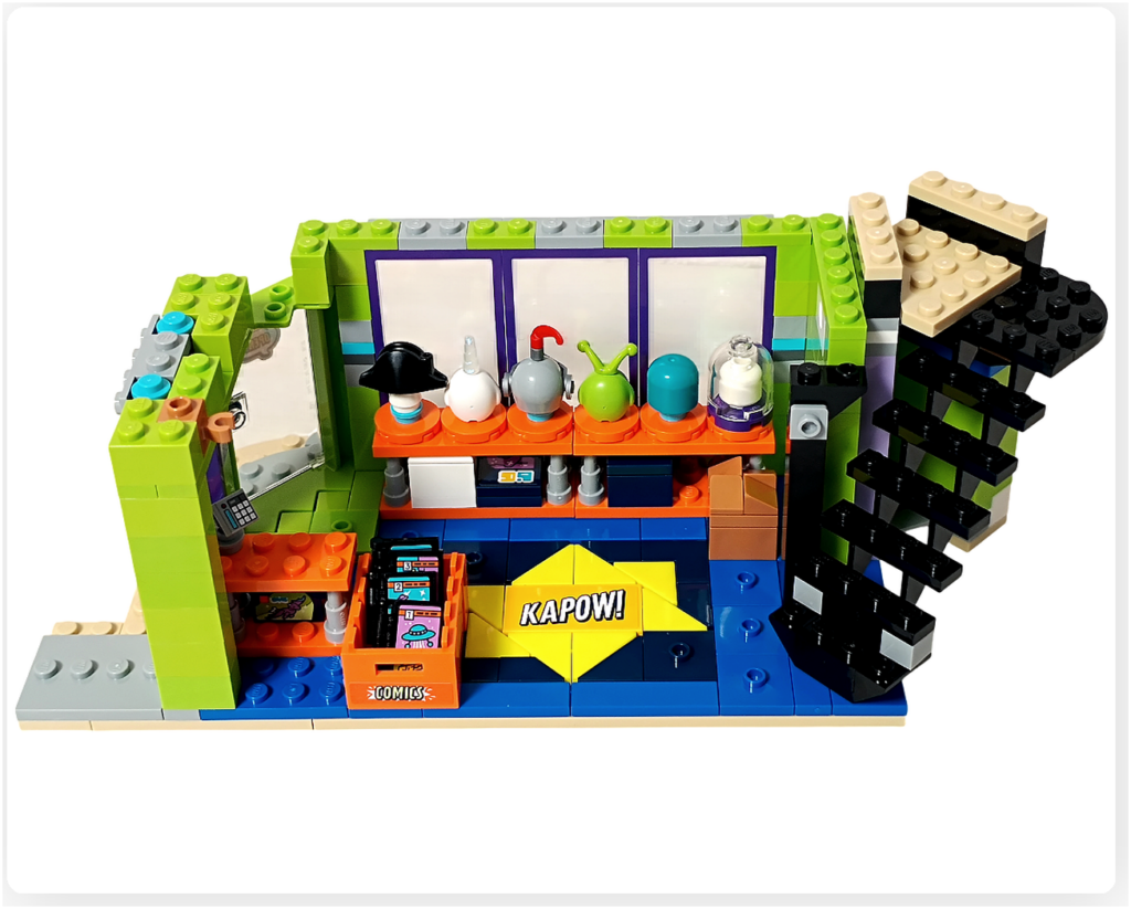 レゴ フレンズ 42674 組立レビューの写真。コミックショップとゲームセンターの店内に、2階へ上がる黒い階段が追加されている。SFディスプレイ棚とコミックストックボックスの横に階段が配置されている。