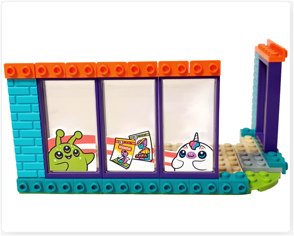 レゴ フレンズ 42674 コミックショップとゲームセンターの2階ゲームセンター正面側。複数のウインドウパーツが並び、ゲームやキャラクターのモチーフが見える外観構成。