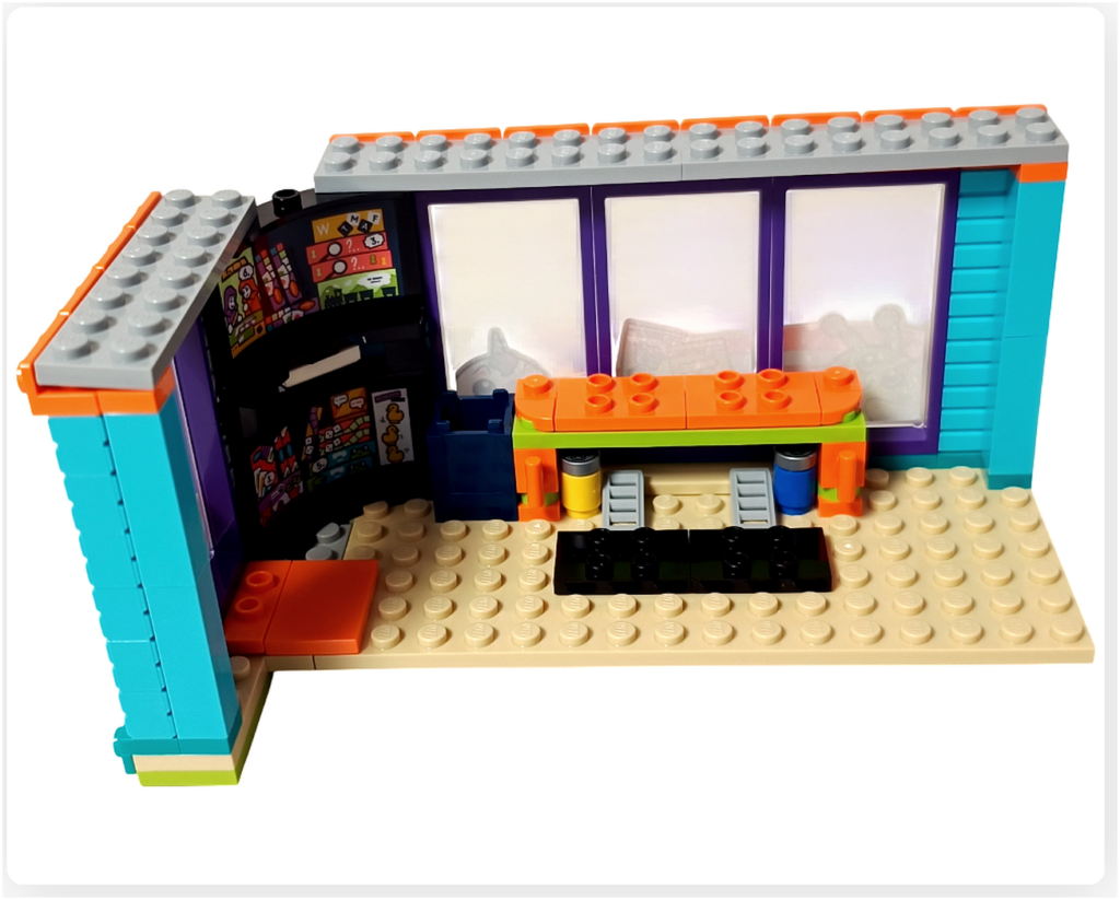 レゴ フレンズ 42674 コミックショップとゲームセンターの2階ゲームセンター内装。中央にゲームテーブルが配置され、周囲にゲームソフト棚やウインドウが並ぶ構造がわかる状態。