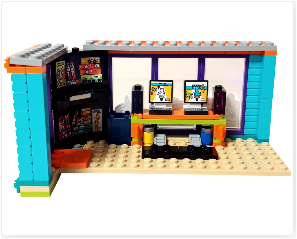 レゴ フレンズ 42674 コミックショップとゲームセンターの2階ゲームセンター内装。ゲームテーブル上にゲーミングPCとディスプレイが設置され、周囲の棚やウインドウとあわせて遊びの中心となる空間が表現されている様子。