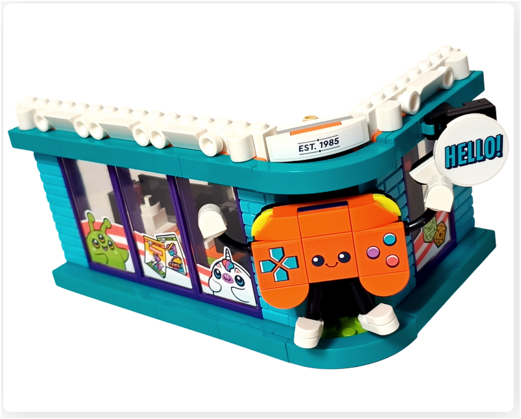 レゴ フレンズ 42674 コミックショップとゲームセンターの外観コーナー装飾。ゲームコントローラー型マスコットが建物角に取り付けられ、「HELLO!」の吹き出し看板と組み合わさった外観デザインがわかる様子。