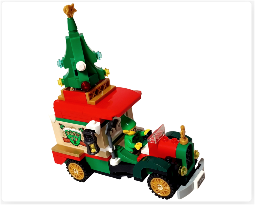レゴ 40746 シーズナル クリスマスプレゼント配達トラックの完成シーン。赤い屋根のトラックが走り出し、屋根の上のミニクリスマスツリーや荷台の装飾が見える状態。エルフのミニフィギュアが運転席に立ち、子どもたちへの贈りものを届けに向かう雰囲気が伝わる写真です。