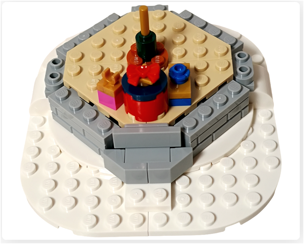 レゴ 40778 雪のあずまや(Winter Gazebo)の組立途中。床板中央に、リボン付きのプレゼントや小物パーツが配置されている。