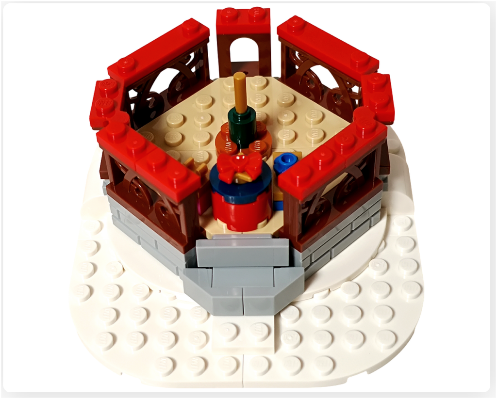 レゴ 40778 雪のあずまや(Winter Gazebo)の組立途中。あずま屋の囲い部分に赤い装飾パーツが追加され、冬の装飾が施されている。