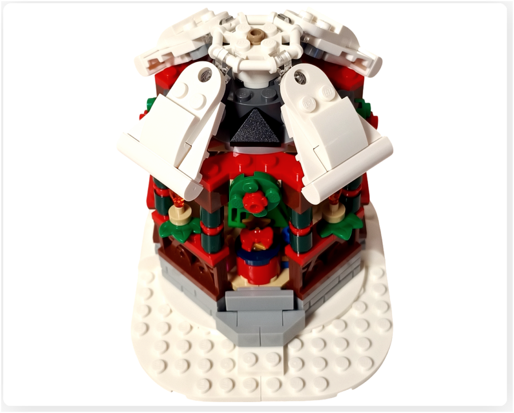 レゴ 40778 雪のあずまや(Winter Gazebo)モデルで、白い屋根パネルを本体に取り付けている途中の様子。屋根が少し開いた状態で重ねられ、内部の装飾が見えている工程写真。