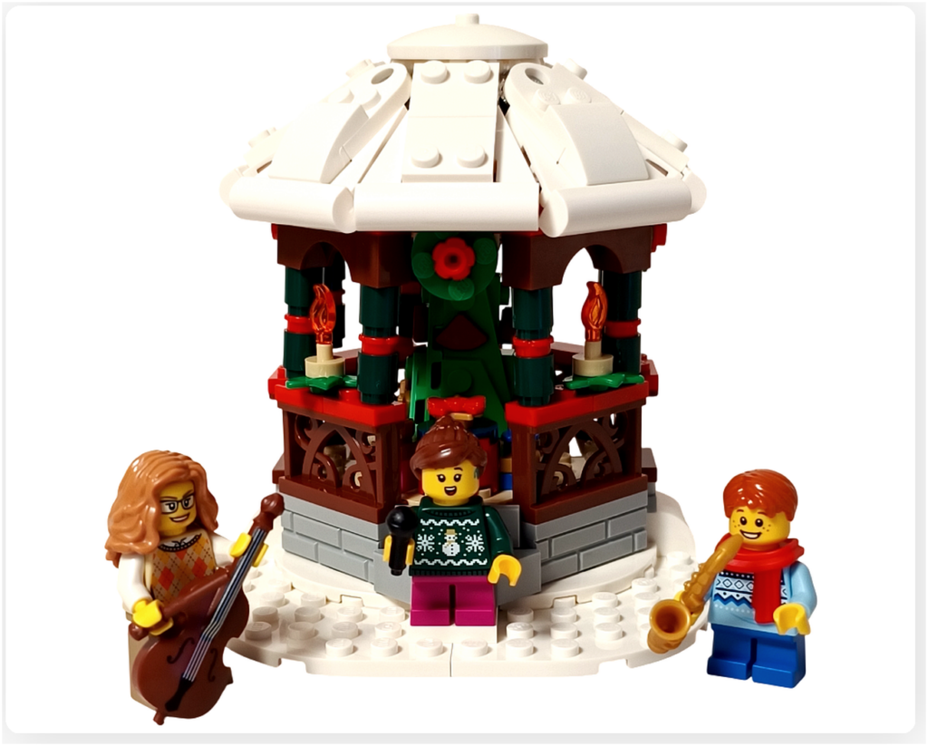 レゴ 40778 雪のあずまや(Winter Gazebo)完成シーン。白い屋根のガゼボ前に、コントラバス奏者・ボーカル・サックス奏者のミニフィグが並び、冬の音楽会の情景を表現している。