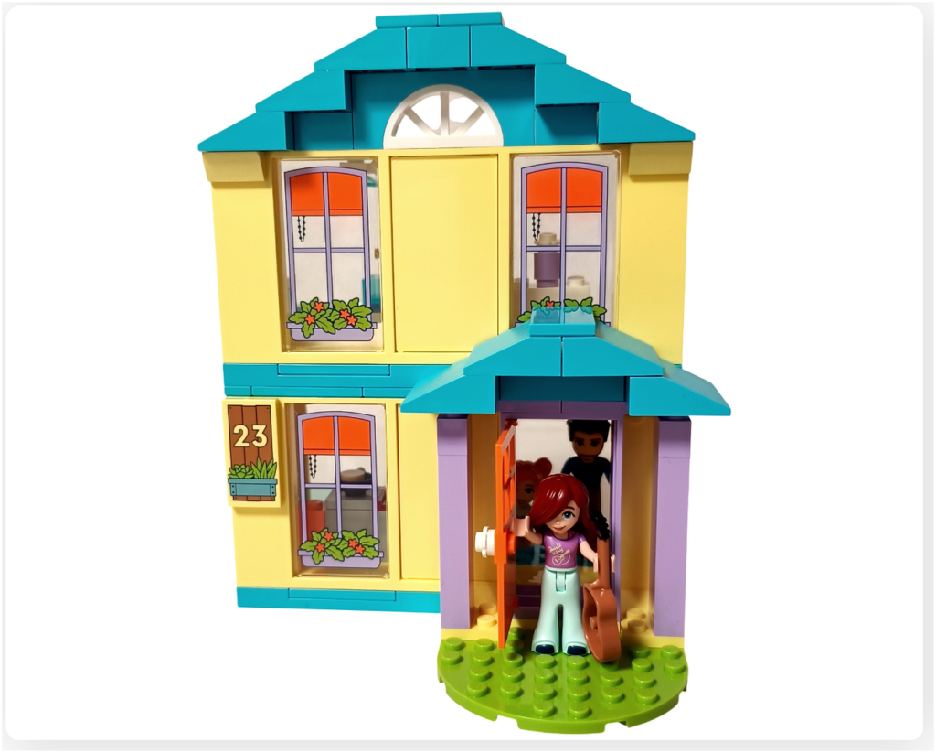 レゴ フレンズ 41724 「ペイズリーのおうち」の完成シーン。ギターを持って玄関から外へ出るペイズリーを、家の中からジョナサンとエラが見送っている様子。