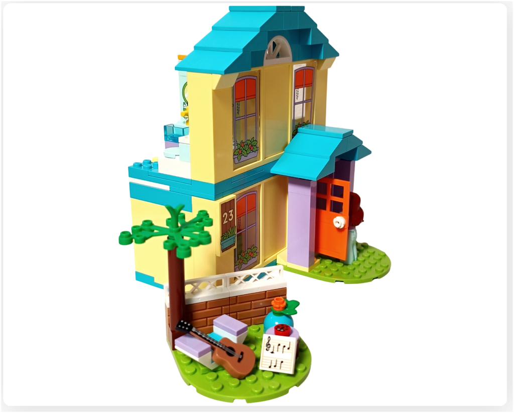 レゴ フレンズ 41724 「ペイズリーのおうち」の完成シーン。家に戻るペイズリーと、庭のくつろぎスペースに置かれたギターと譜面が、音楽の余韻として残っている様子。