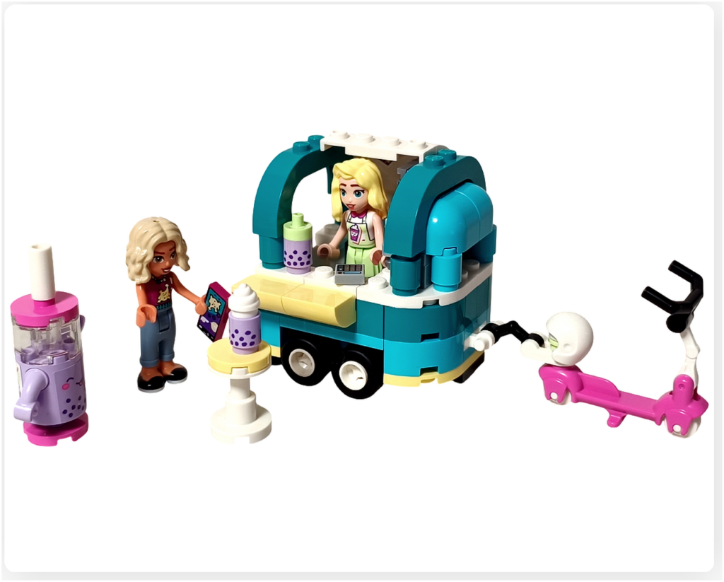 レゴ フレンズ 41733「タピオカティスタンド」組立完成シーン。屋台の前で店員のマチルダとお客のノヴァが向かい合い、タピオカドリンクや電気スクーター、小さなテーブルが並ぶ様子。