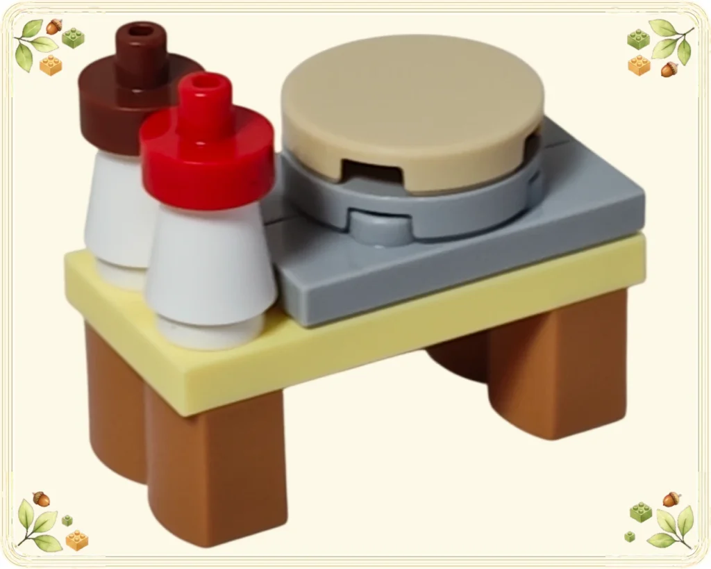 レゴ 42698 レゴフレンズ アドベントカレンダー2026 グレーの作業面に丸いケーキを載せ白い絞り袋2個を並べたデコレーション台の完成